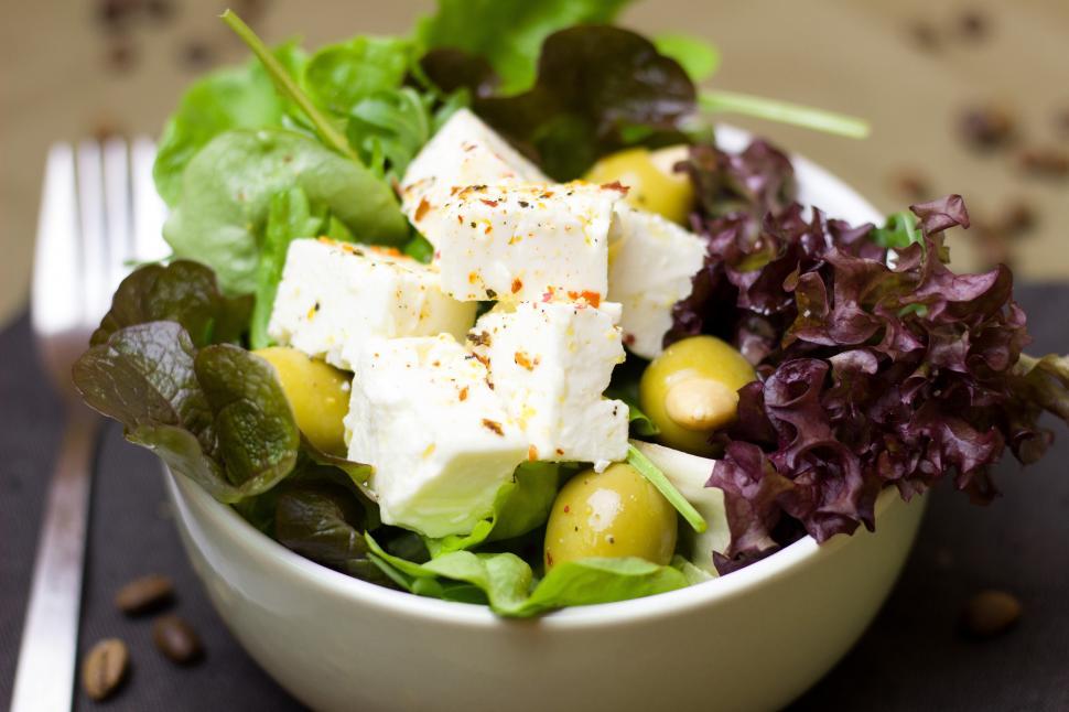 Free Image of A bowl of salad with olives and cheese 