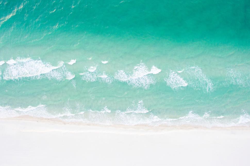 Free Image of A beach with blue water and white sand 