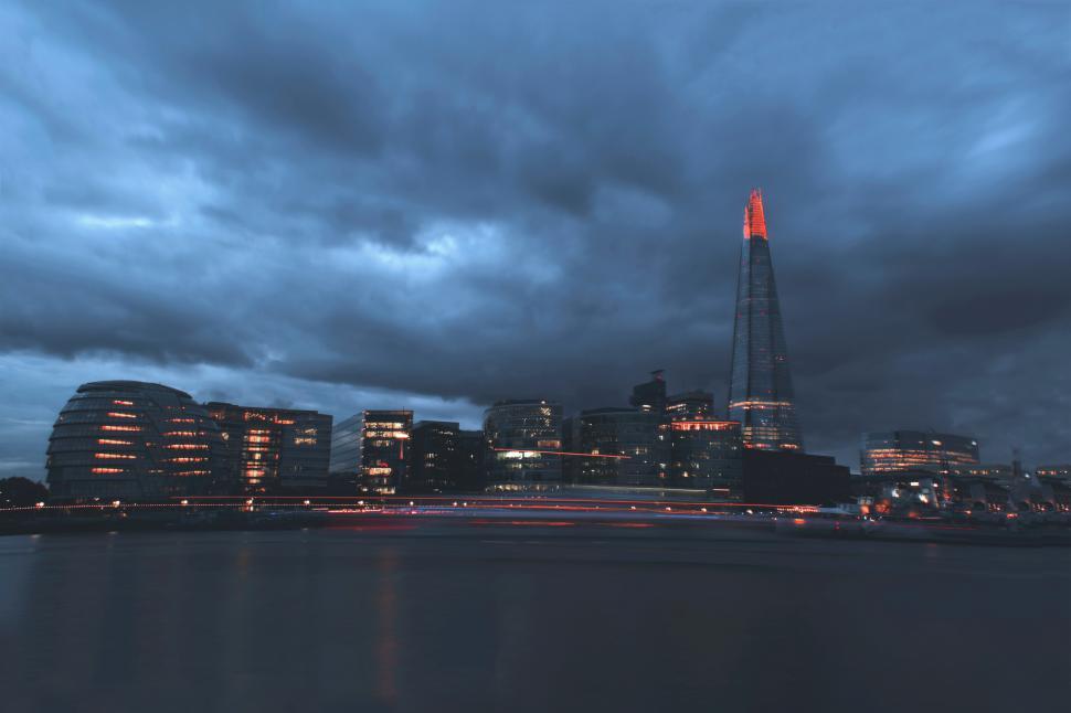 Free Image of A city skyline with a tall tower and a body of water 