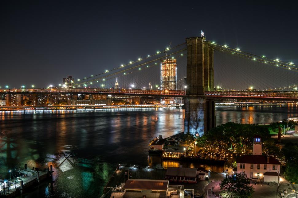 Free Image of A bridge over water with lights at night 