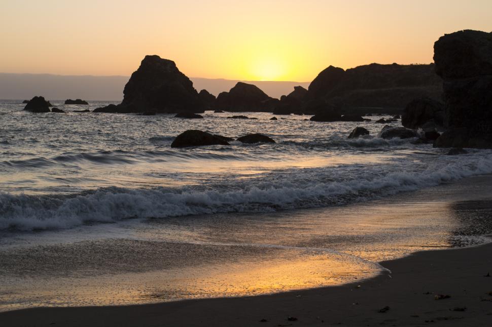 Free Image of A sunset over a beach 