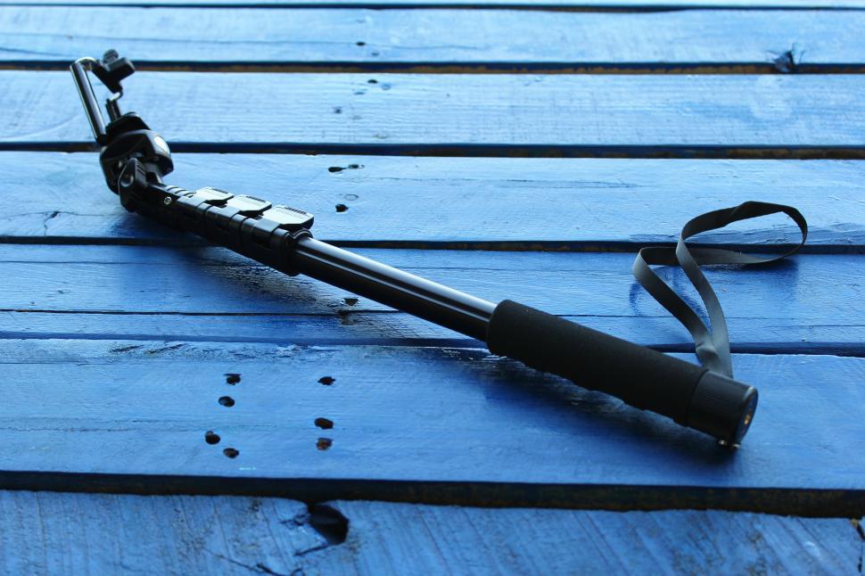 Free Image of A black pole with a strap on a blue wood surface 