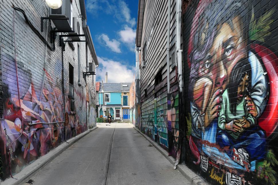 Free Image of A street with graffiti on the side of a building 