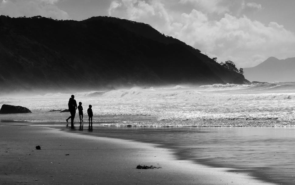 Free Image of A group of people walking on a beach 