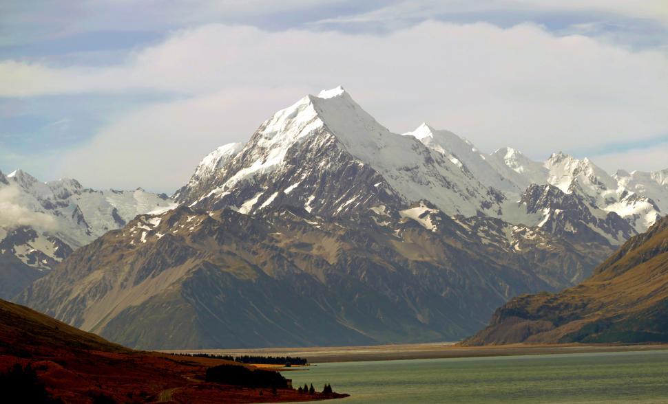 Free Image of A snowy mountain with a body of water 
