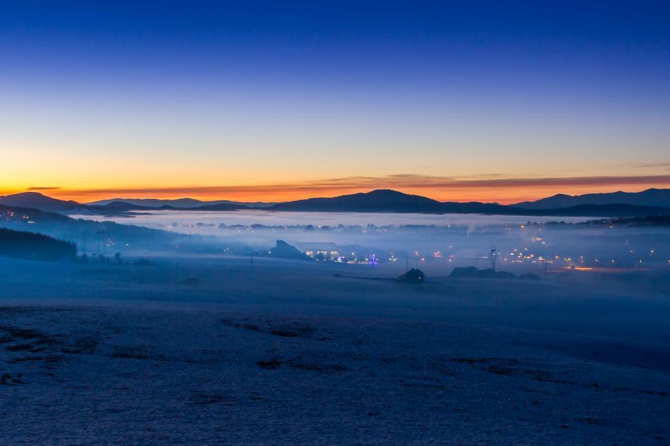 Free Image of A foggy landscape with a city in the distance 