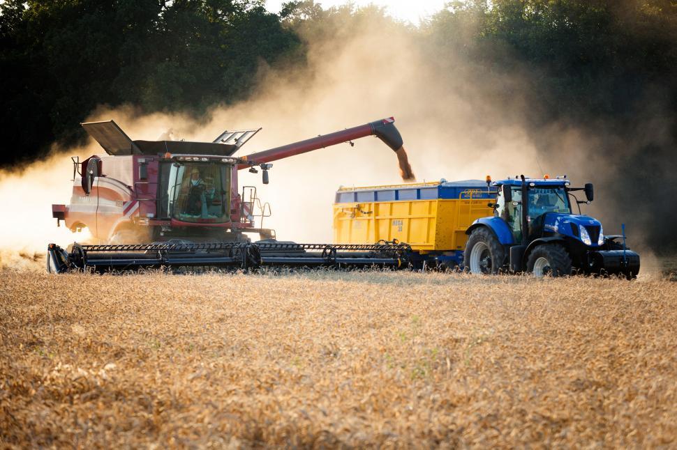 Free Image of A tractor loading a truck into a truck 