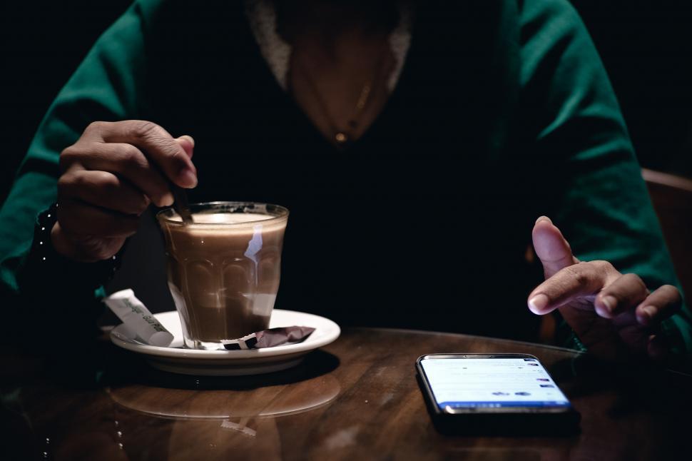 Free Image of A person holding a spoon in a glass cup 