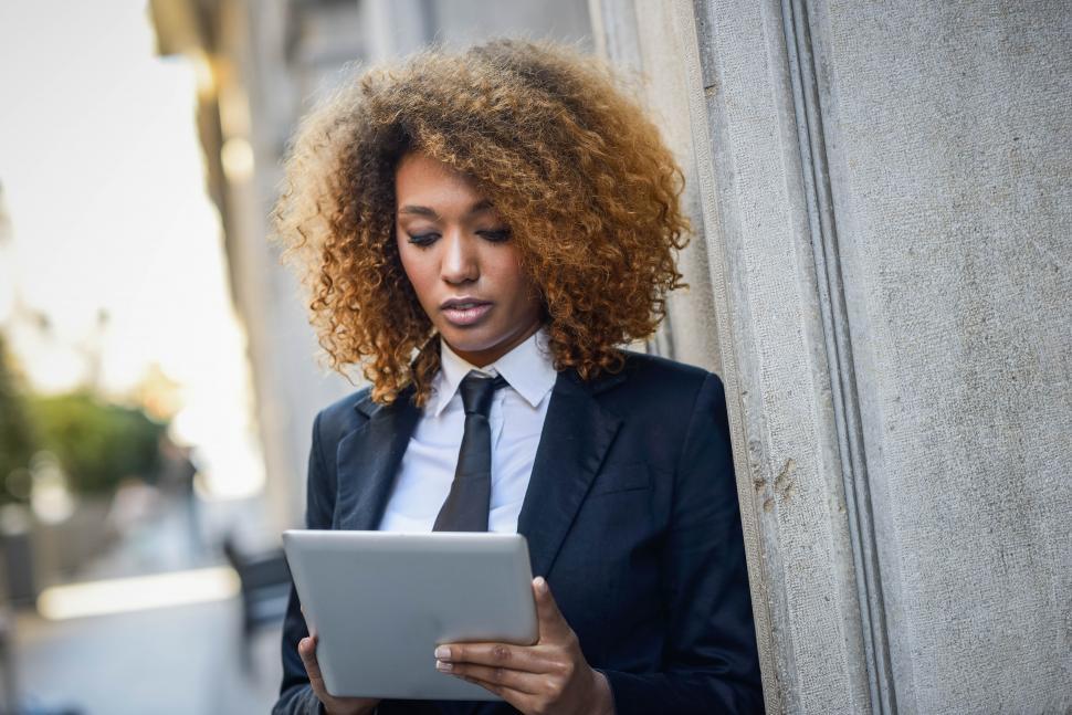 Free Image of Black woman using tablet computer in town 
