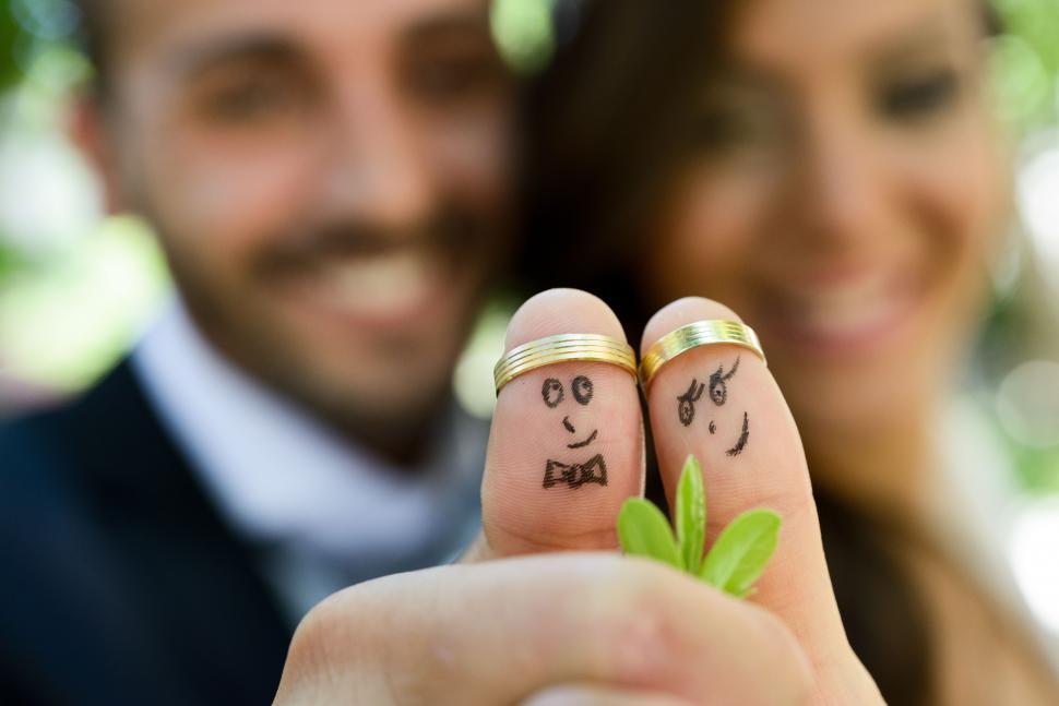 Free Image of wedding rings on their fingers painted with the bride and groom 