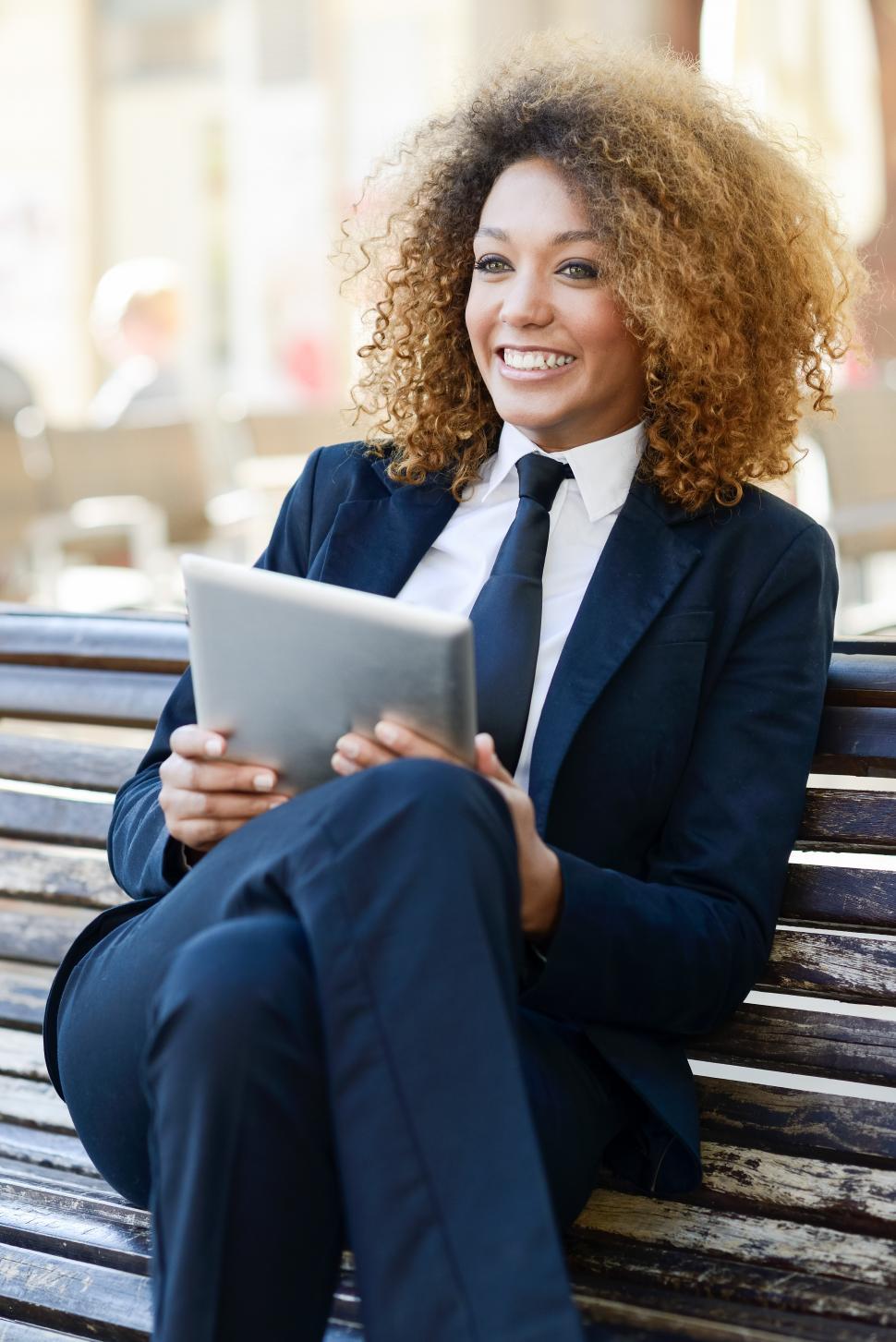 Free Image of Black woman using tablet computer in town 