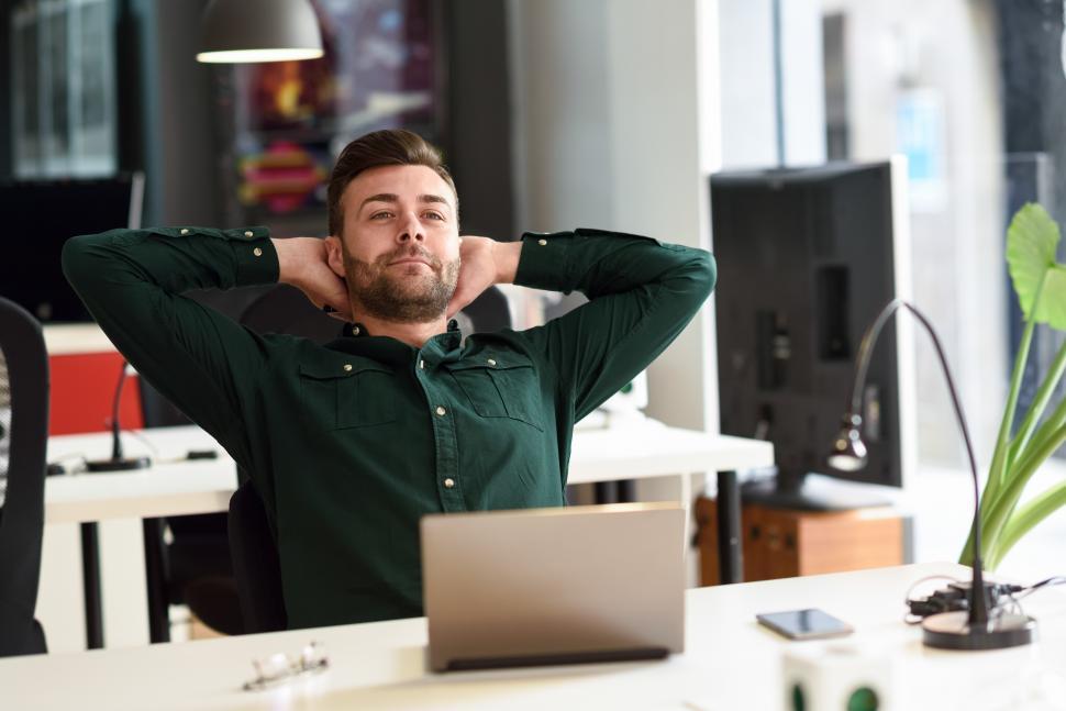 Free Image of Young man studying with laptop computer on white desk. 