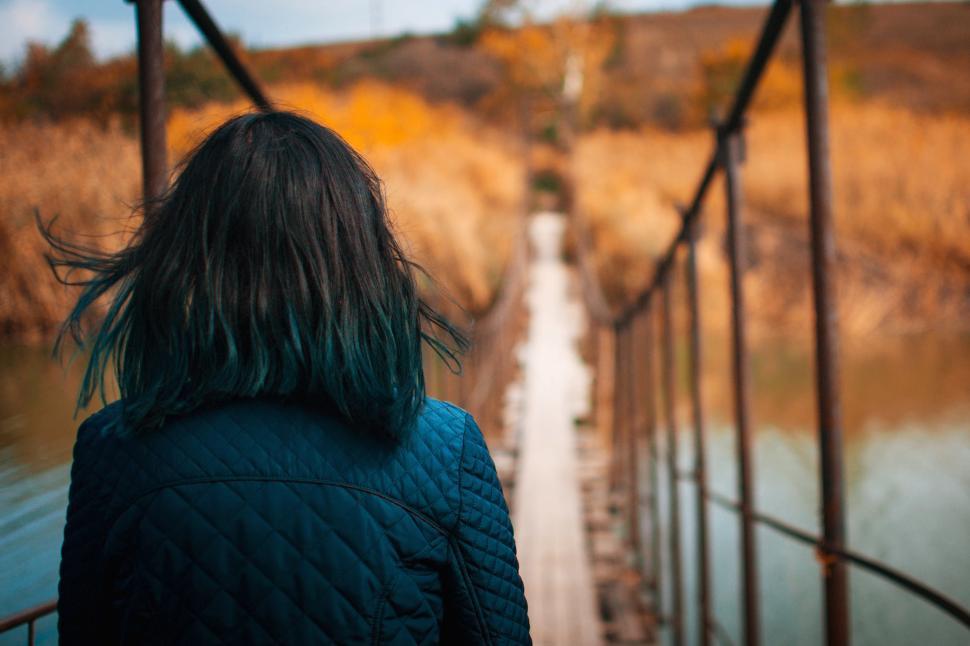Free Image of A woman walking on a bridge 