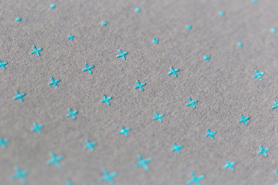Free Image of A group of blue crosses on a grey surface 