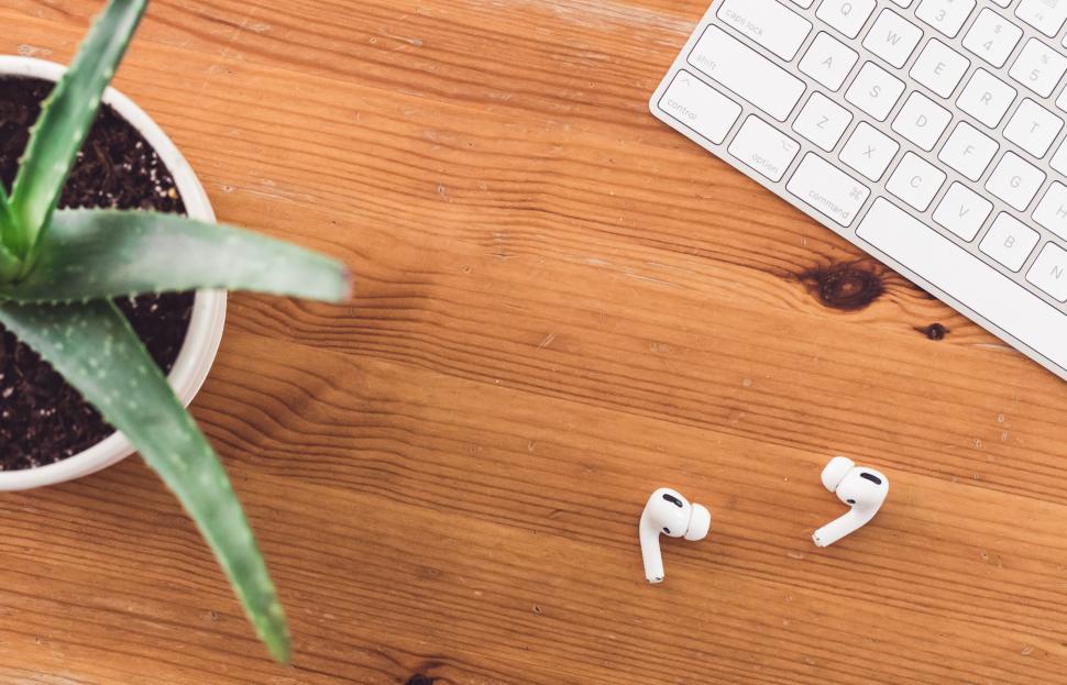 Free Image of A keyboard and earbuds on a table 