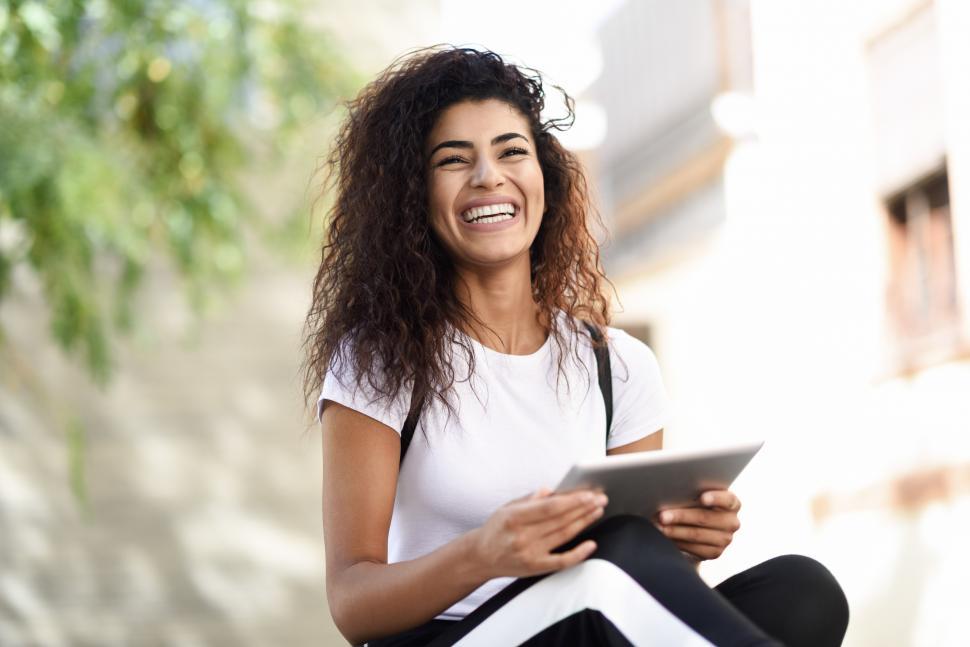 Free Image of Young black woman in sportswear using digital tablet outdoors 