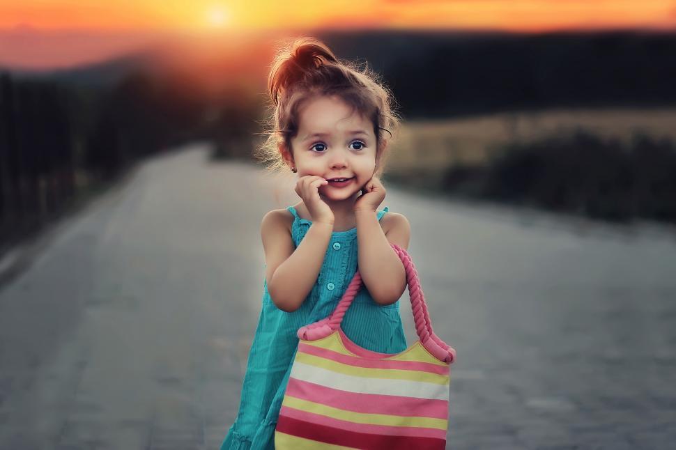 Free Image of A girl holding a striped bag 