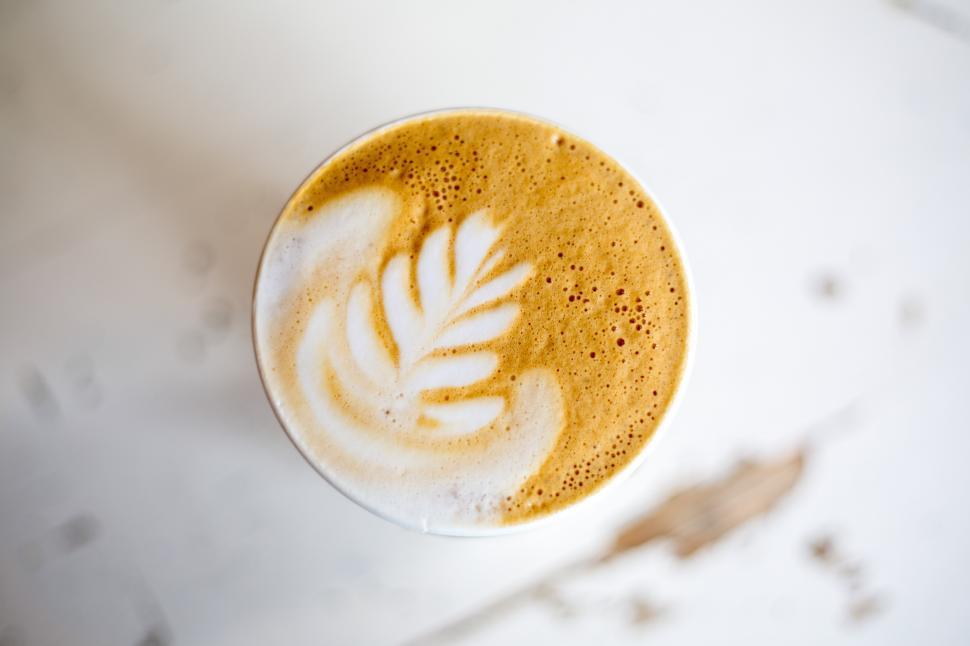 Free Image of A cup of coffee with a leaf design on top 