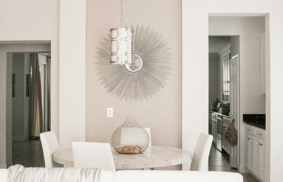 Free Image of A dining table with a round table and chairs in a room 