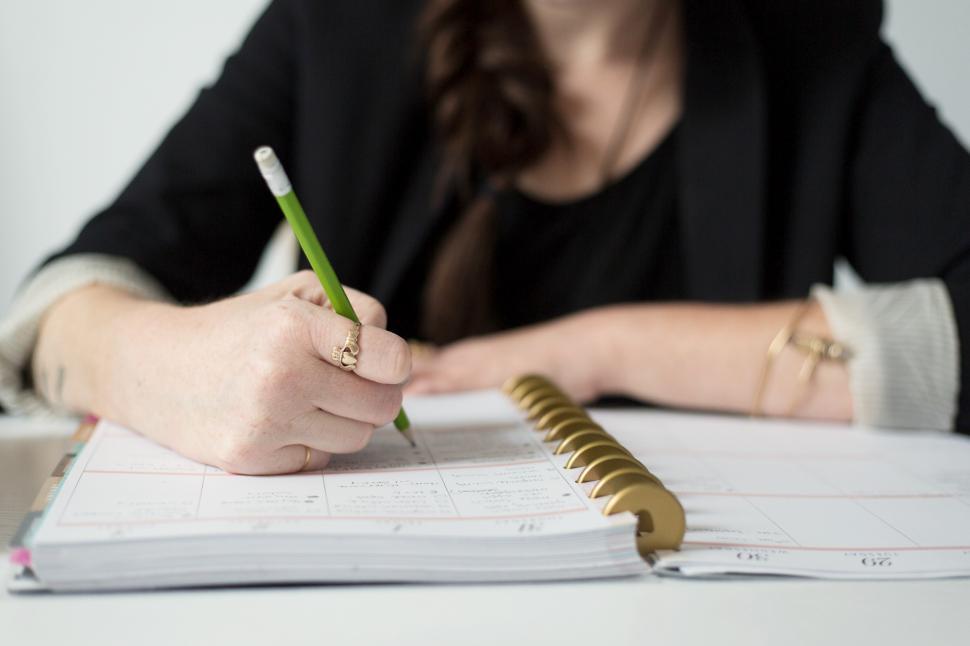 Free Image of A person writing on a book 