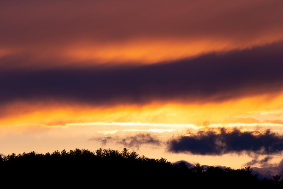 Free Image of A sunset with clouds and trees 
