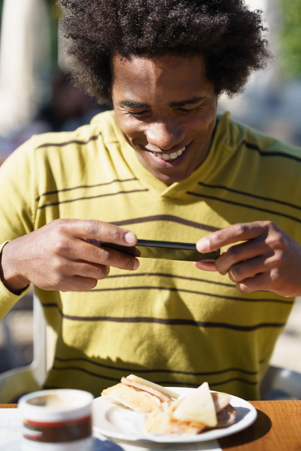 Free Image of Man taking a photo with his smartphone to a snack 