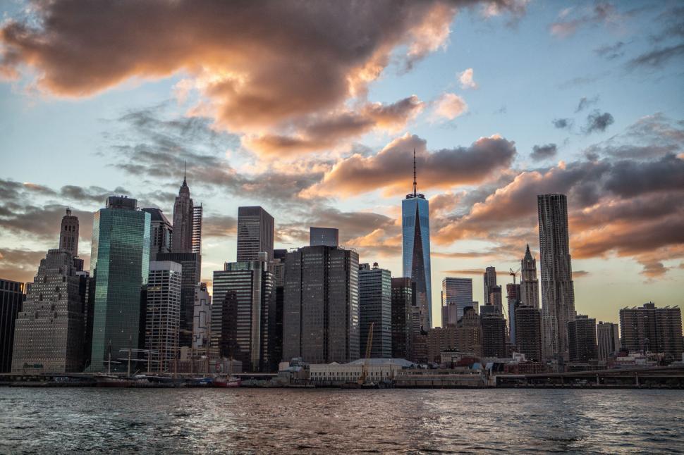 Free Image of A city skyline with water and clouds 