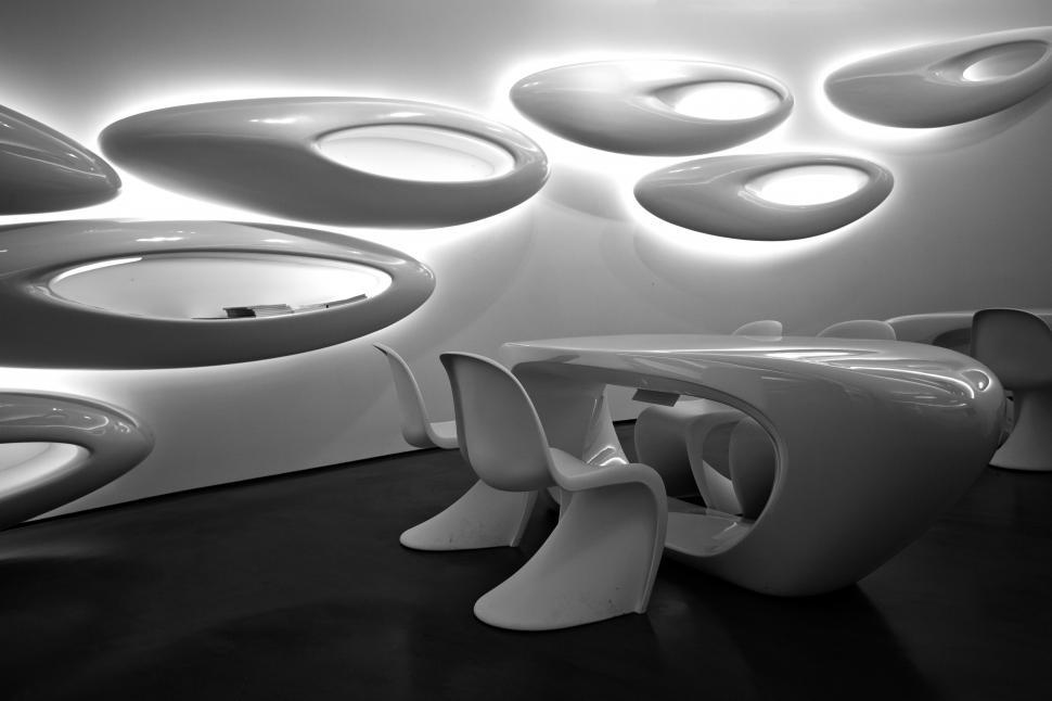 Free Image of A white table and chairs in a room with oval shaped lights 