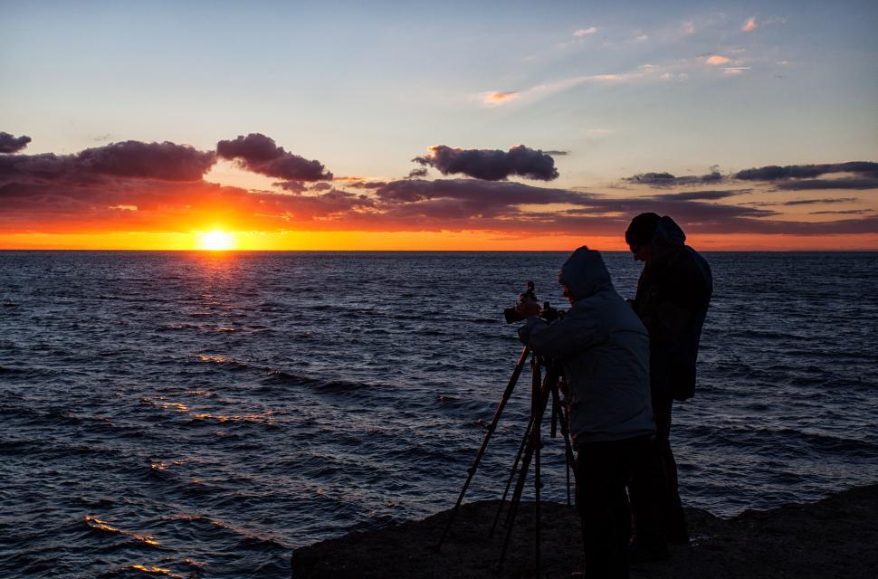Free Image of A group of people standing on a rock with a camera on a tripod 