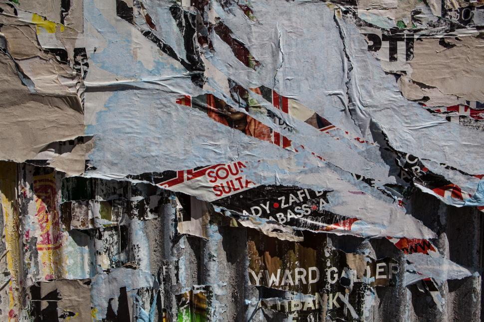 Free Image of A wall with torn posters 