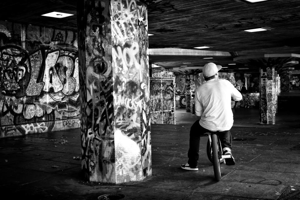 Free Image of A man riding a bicycle in a parking lot 