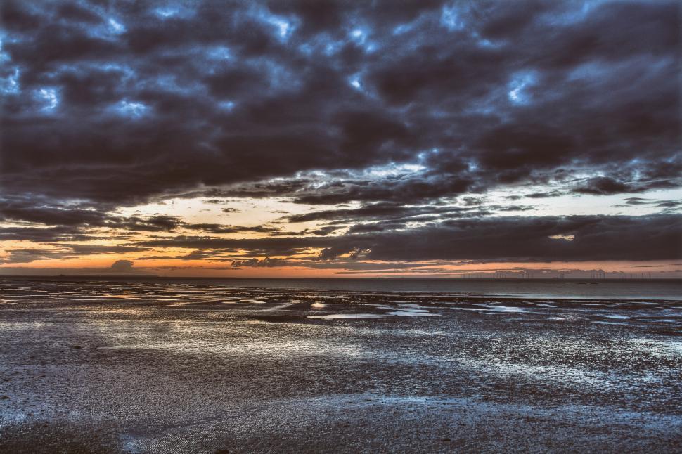 Free Image of A sunset over a beach 