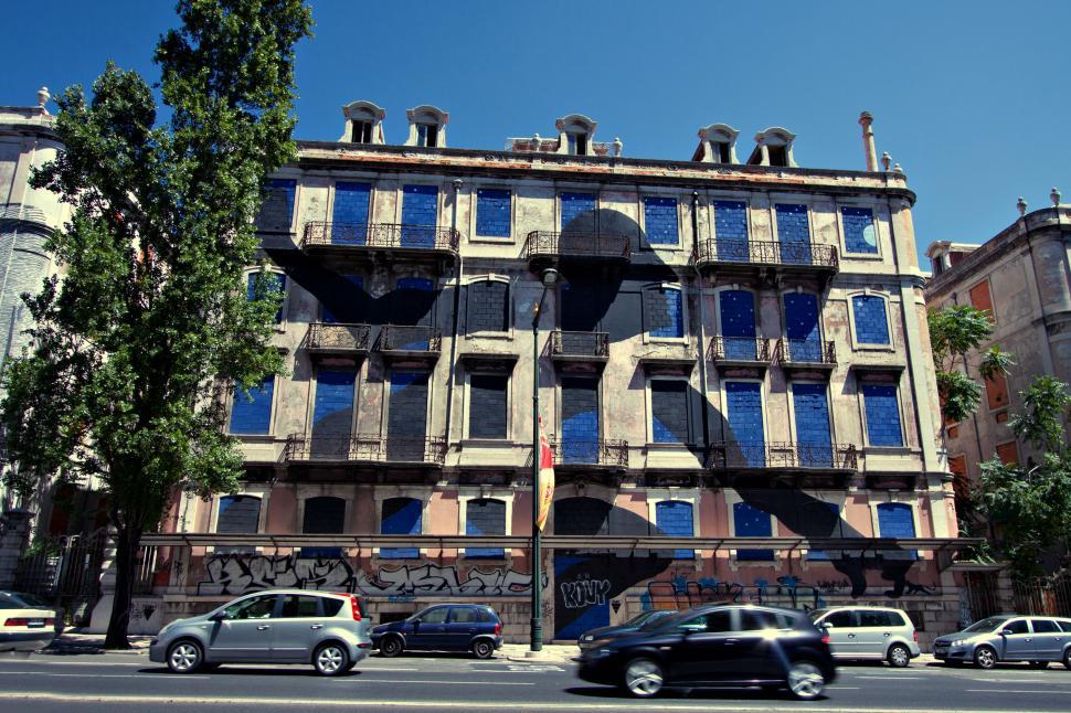 Free Image of A building in Lisbon with graffiti on the side of it 
