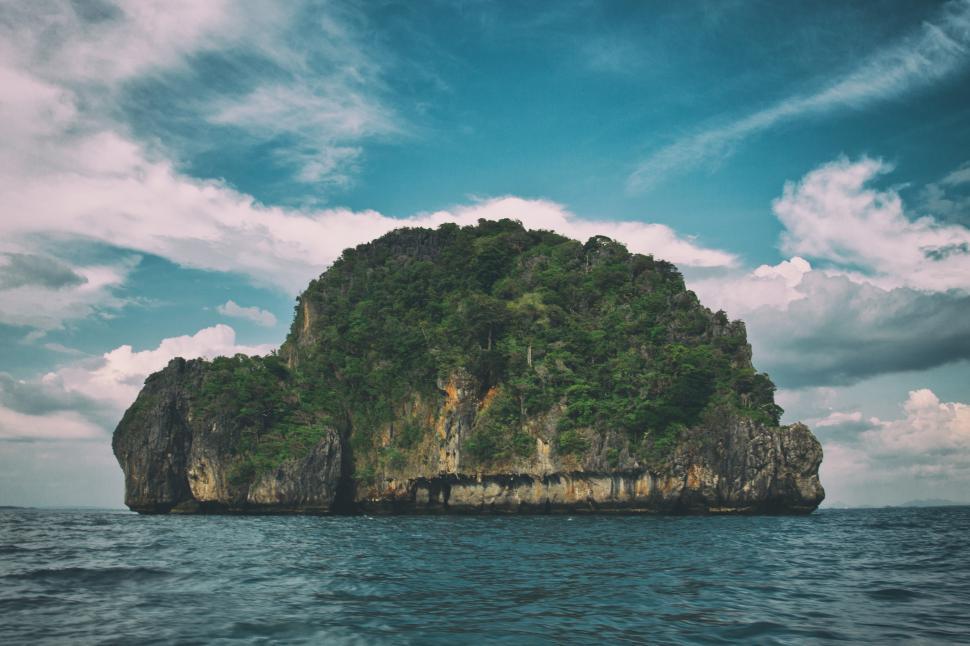 Free Image of A large rock island with trees on it 