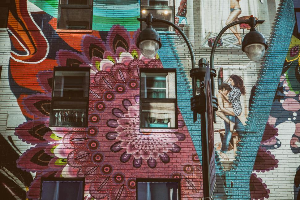 Free Image of A street light next to a building with a mural on the side 