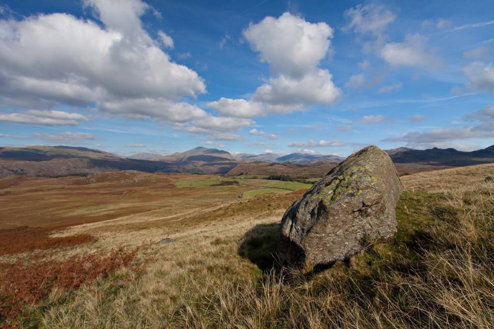 Free Image of A large rock in a grassy field 