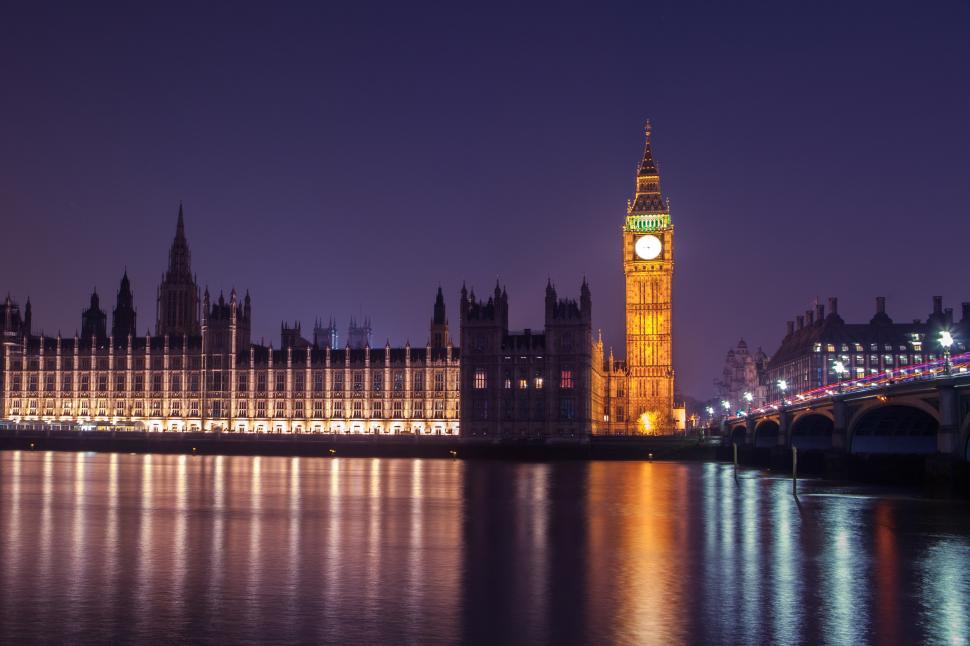 Free Image of A large building with a clock tower and a bridge over water 