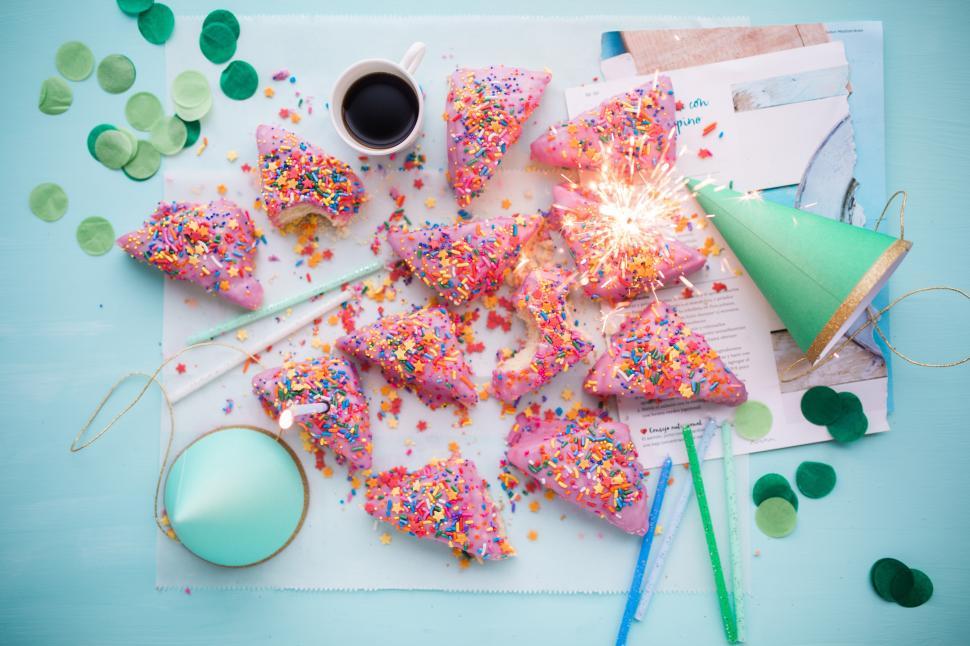 Free Image of A pink cupcakes with sprinkles and a cup of coffee 