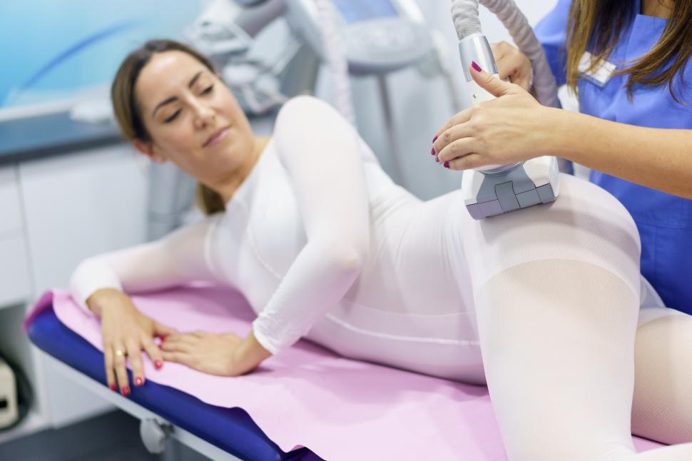 Free Image of Woman in special white suit having a anti cellulite massage with spa apparatus 