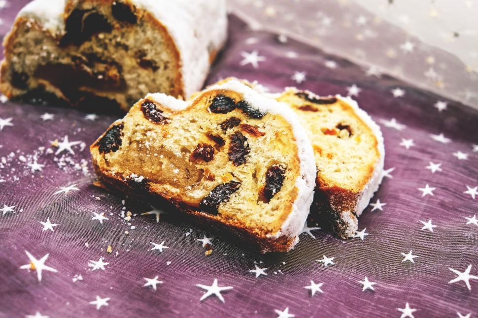 Free Image of A sliced bread with raisins on a purple surface 