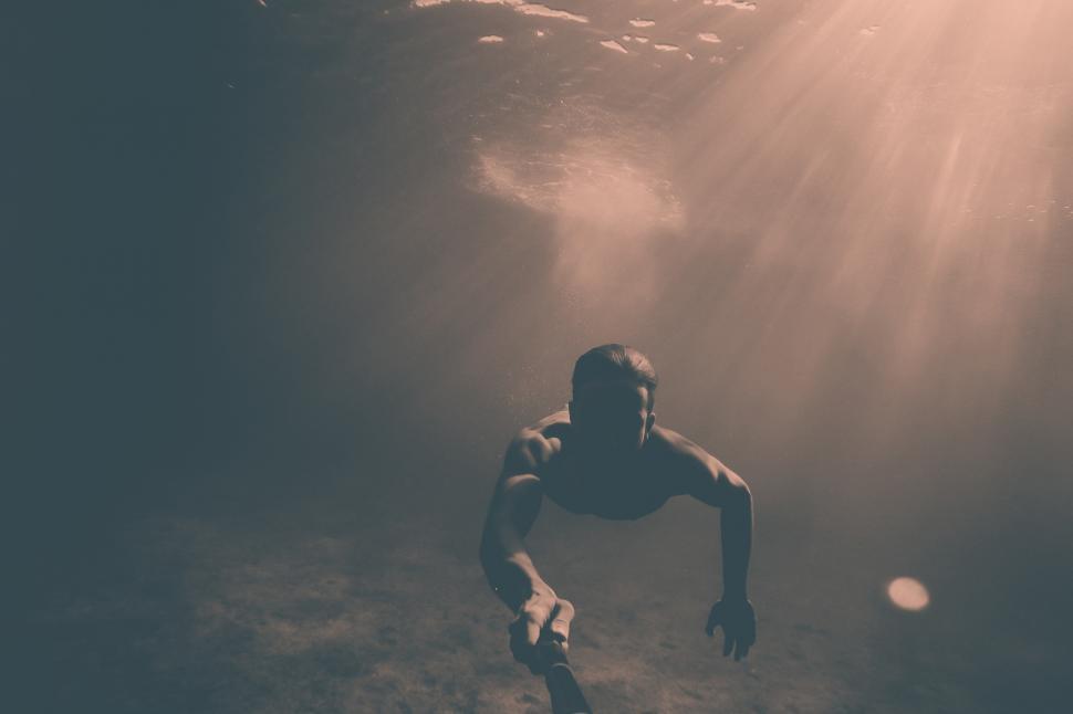 Free Image of A man underwater with a stick 