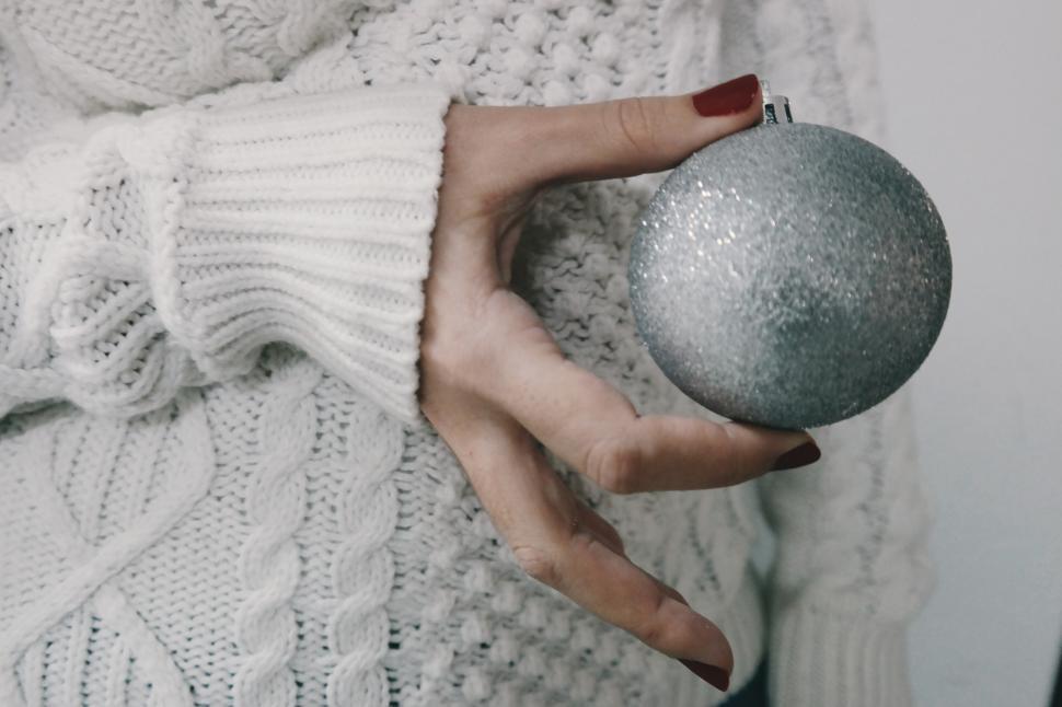 Free Image of A hand holding a silver ornament 