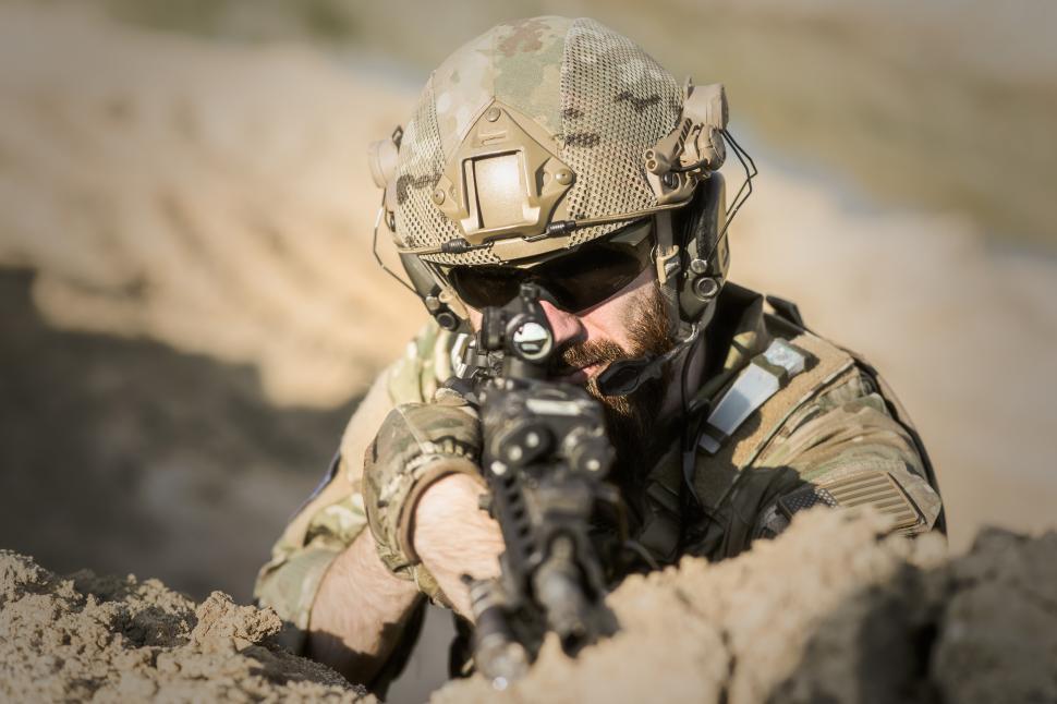 Free Image of A man in military uniform aiming a gun 
