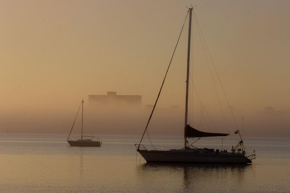 Free Image of Two Boats Floating in Water on Foggy Day 