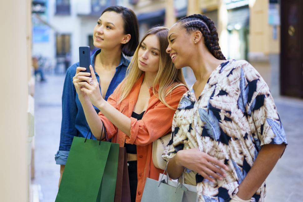 Free Image of Multiethnic women taking photo of showcase while choosing goods 