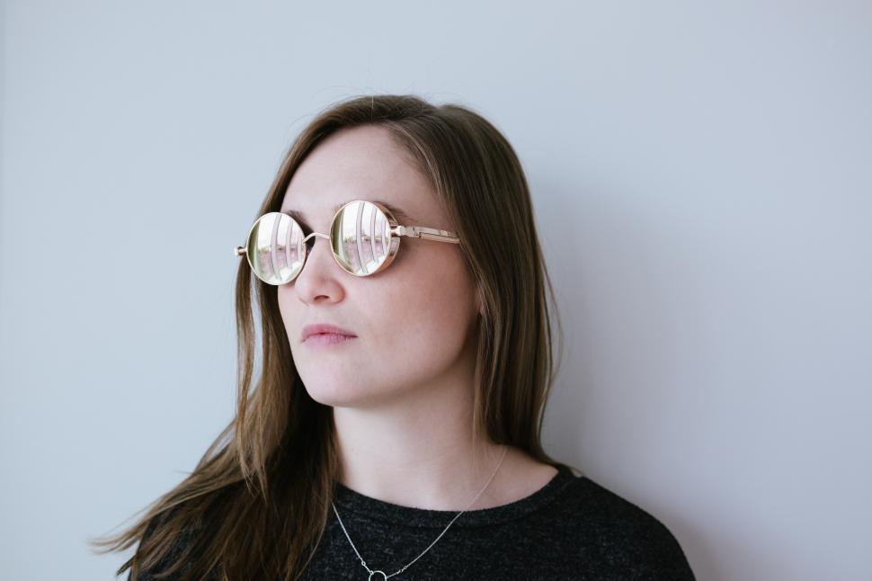Free Image of A woman wearing sunglasses and looking at the camera 