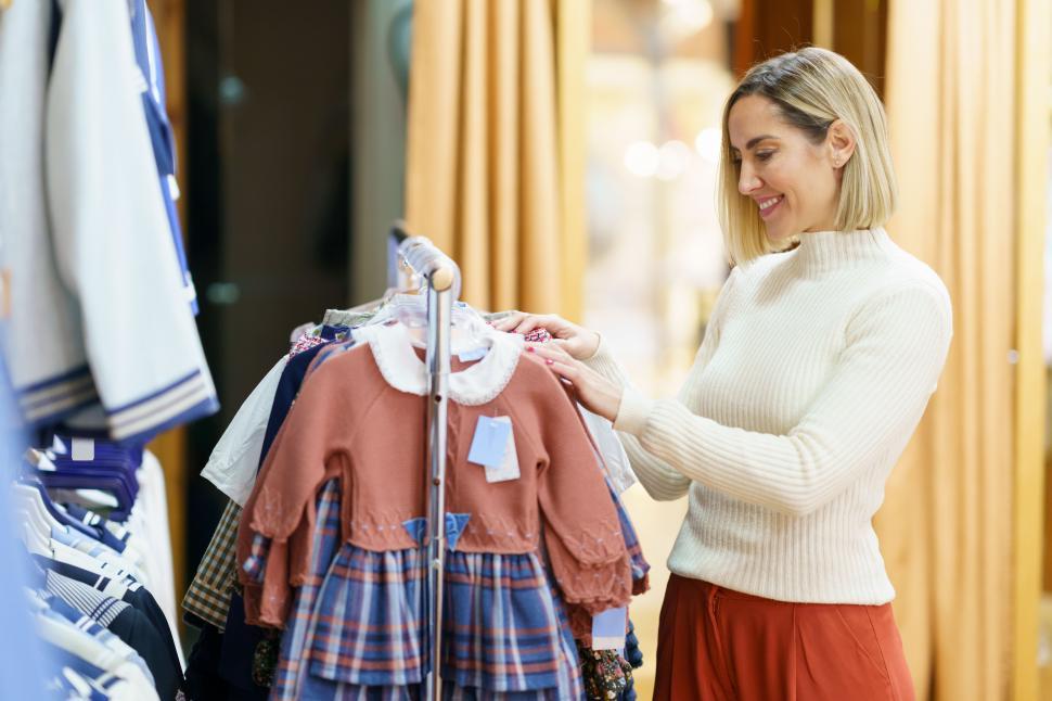 Free Image of Content woman choosing clothes for little girl 