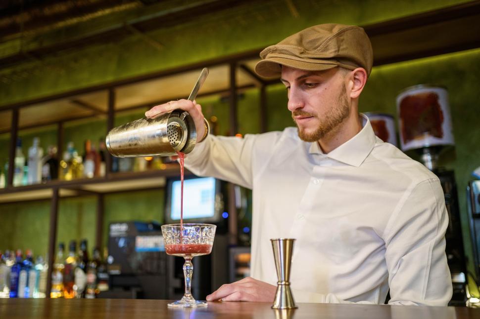 Free Image of Barman pouring cocktail into glass 