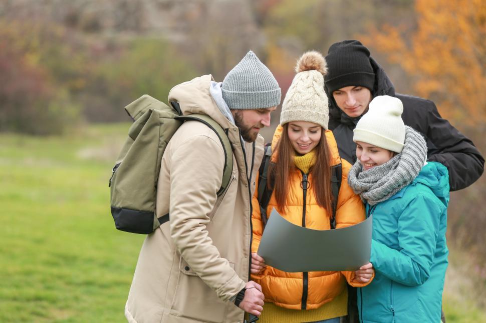 Free Image of A group of people looking at a piece of paper 