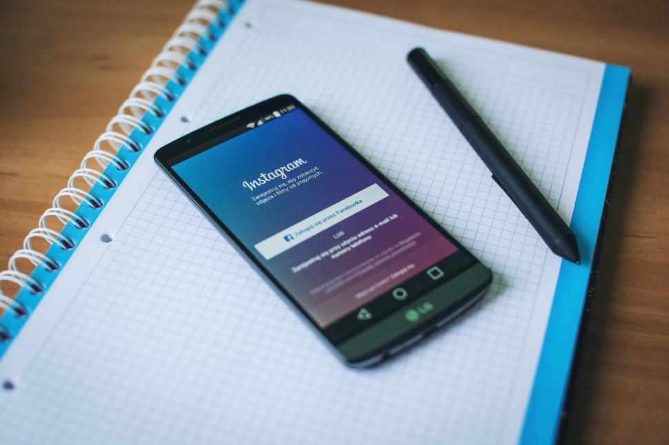 Free Image of A cellphone on a notebook 